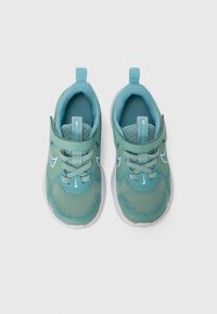 Baskets de sport en bleu clair avec tige en mesh, une sangle à boucle et des accents blancs. Bout rond et semelle rembourrée.