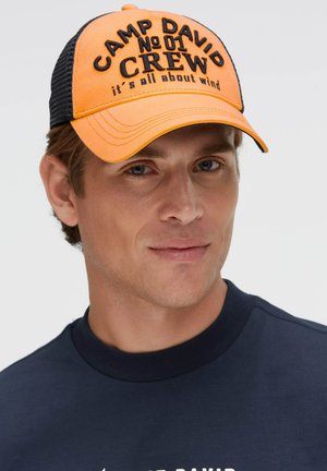 Orangenes Trucker-Cap mit schwarzem Mesh-Rücken, bestickt mit dem Text: "CAMP DAVID No 01 CREW" und "it's all about wind."