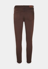 Brown, fitted jeans with a smooth texture. Features include two back pockets, a leather label at the waistband, and a slim, tapered leg design.
