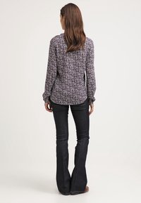 Bloemmotief lange mouw shirt van een lichtgewicht stof, met paarse, blauwe en groene accenten, voorzien van een ronde zoom en gerimpelde mouwmanchetten.