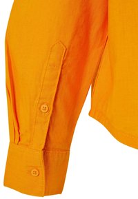 Long-sleeve shirt with orange, textured fabric. Features a pointed cuff with two matching buttons and a side slit for ease of movement.