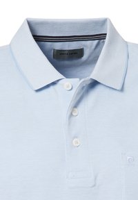 Hellblaues Poloshirt aus strukturiertem Stoff, mit zwei weißen Knöpfen und einem Kragen. Verfügt über ein kleines, gesticktes Logo auf der Brust.