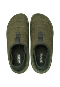 Scarpe slip-on verde oliva con una tomaia testurizzata, design trapuntato e rivestimento in pile. Presentano un'etichetta sul tallone. Suola morbida e imbottita.