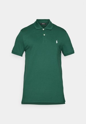 Temno zelena polo majica iz gladkega bombaža, z ovratnikom, tremi gumbi in majhnim belim logotipom na levem prsnem delu. Kratkimi rokavi.