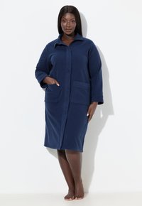 Námořnicky modrý župan z fleecu s límcem, dlouhými rukávy, dvěma předními kapsami a celopropínacím zipem, s měkkou a hladkou texturou.