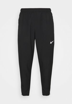 Zwarte sportieve broek met een elastische tailleband en ritsen bij de enkels. Heeft een klein wit Nike-logo aan de linkervoorzijde.