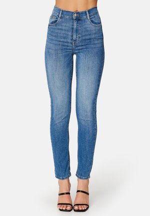 Dżinsy skinny z wysokim stanem w jasnoniebieskim denimu, z pięcioma kieszeniami, szlufkami na pasek oraz delikatnym przetarciem. Gładka tekstura i zwężana nogawka.