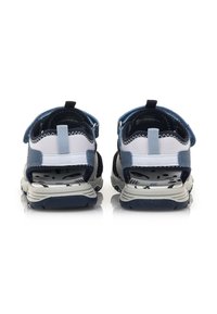 Sandalias abiertas en azul y gris con correas ajustables, plantilla texturizada, soporte acolchado para el tobillo y suela de goma con un diseño estampado.