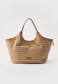 Sac fourre-tout en paille tressée marron avec des accents en cuir, doté de deux anses et d'une forme structurée. Rayures horizontales subtiles et étiquette de logo.