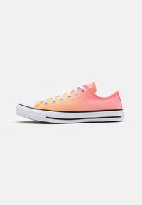 Trampki z płótna z pomarańczowo-różowym gradientem, gumową podeszwą, białymi sznurowadłami i czarną paskową wkładką.