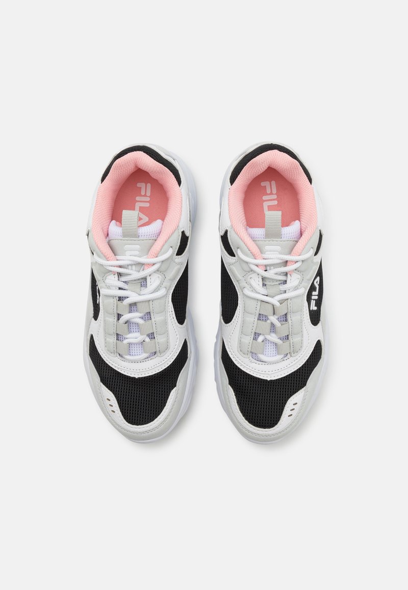 Sneakers in bianco e nero a rete con accenti rosa chiaro. Le caratteristiche includono un collare imbottito, lacci bianchi piatti e un logo sul lato.