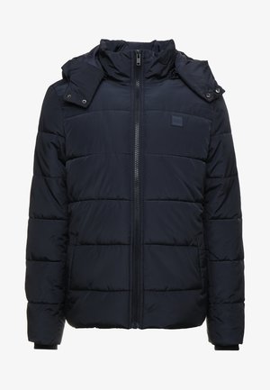 Chaqueta de plumas azul marino con cierre de cremallera, cuello alto y capucha desmontable. Patrón de acolchado horizontal y bolsillos laterales. Material suave.