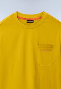 Yellow short-sleeve t-shirt made of cotton, featuring a round neck, chest pocket with embossed logo, and contrasting inner neck color.