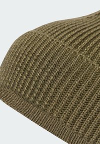 Olīvu zaļš adīts cepure ar ribotu tekstūru, gludu virsmu un elastīgu, siltu dizainu. Piemērota aukstam laikam.