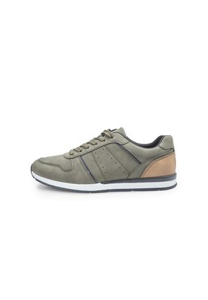 Baskets vert olive avec une texture lisse, dotées d'un accent en cuir brun, d'une semelle blanche et de perforations discrètes sur les côtés.