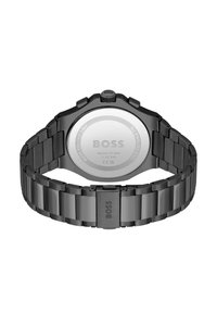 Orologio da polso in acciaio inossidabile nero con bracciale a maglie, cassa tonda, corona prominente e fondello liscio in argento con logo del marchio.