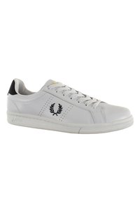 White leather sneaker with black heel accent, perforated side detailing, and embroidered logo on the outer side. Flat rubber sole.