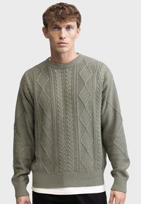 Olive green knitted sweater with diamond and cable patterns, a crew neck, ribbed cuffs, and hem; textured fabric, relaxed fit.