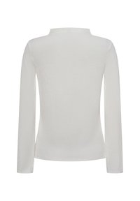 Haut à manches longues blanc en tissu texturé. Il présente un col montant et une coupe ajustée, avec des épaules sans couture.