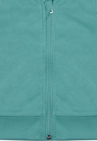 Felpa con zip in tessuto teal, caratterizzata da una texture liscia e orli e polsini a coste. Zip al centro con tirazip metallico.