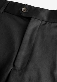 Pantaloni negri dintr-un material neted, cu închidere prin buton, design elegant și cusături vizibile pe margini.