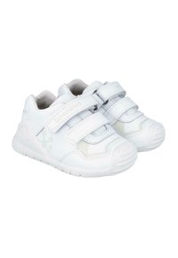 Zapatillas blancas para niños con doble tira de Velcro, fabricadas en material sintético suave, puntera redondeada y suela de goma texturizada con patrones de agarre.
