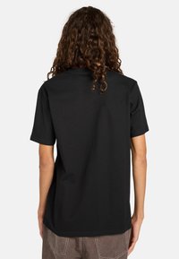 T-shirt nera in cotone con maniche corte e vestibilità rilassata. Tessuto liscio con collo rotondo e bordi rifiniti. Nessuna grafica o motivo visibile.