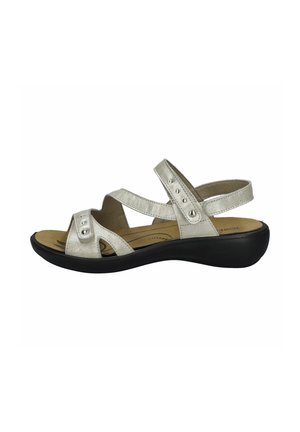 Silver metallic sandals with cross straps, decorative studs, and a black rubber outsole. Cushioned footbed for comfort.