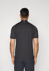 Svart kortermet sportskjorte, tettsittende design, glatt tekstur, med en subtil gulldetalj på baksiden av halsen.