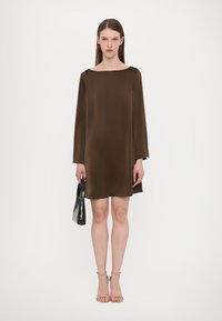 Bruna satiinimini kleit pikkade varrukatega ja laia kaelusega. Kombineeritud beige rihmadega kontsakingade ja tekstureeritud musta käekotiga.