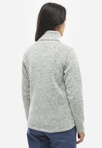 Pull en polaire texturé gris avec un col haut. L'arrière présente un ourlet incurvé et est conçu pour offrir chaleur et confort.
