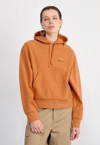 Orange sweatshirt with a hood, kangaroo pocket, ribbed cuffs, and hem. Features a small yellow logo on the chest. Cotton blend material.