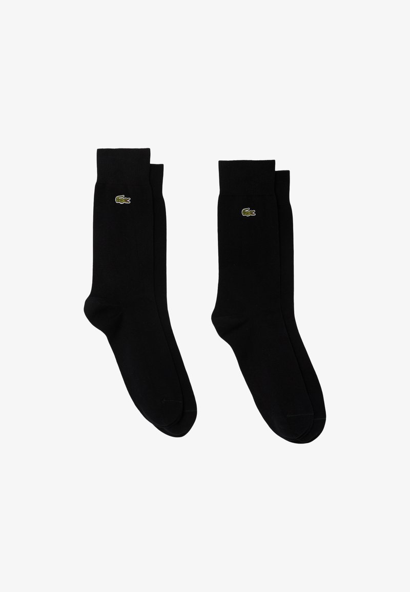 Calzini neri in cotone con polsini a coste e logo verde Lacoste sul lato esterno, caratterizzati da una superficie liscia e una lunghezza standard da crew.