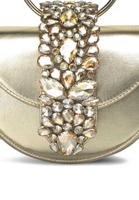 Bolso de mano metálico dorado con una correa decorada con piedras preciosas transparentes y ámbar en varias formas, que realzan su superficie texturizada.
