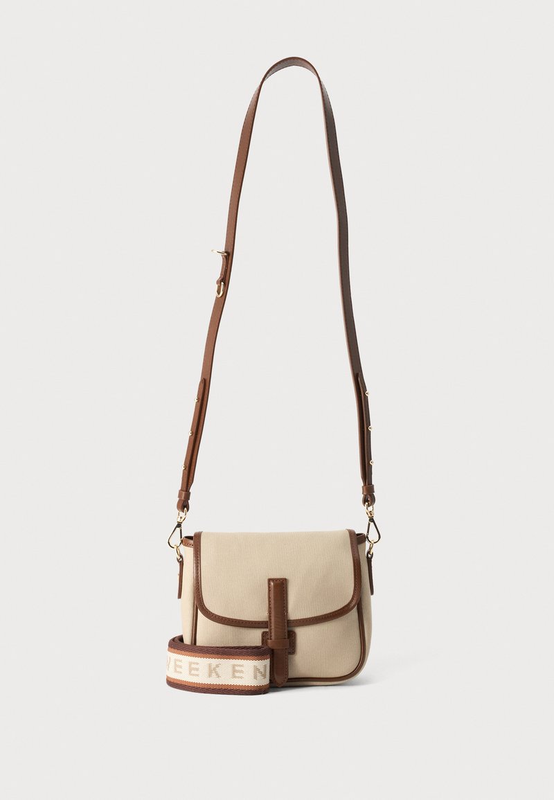 Μπεζ τσάντα crossbody με καφέ επένδυση και ρυθμιζόμενο καφέ λουρί ώμου, παρουσιασμένη σε απλό φόντο.