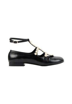 Chaussure plate noire avec bride de cheville et perles décoratives le long de la bride en T et sur les côtés, finition cuir lisse, talon bas.