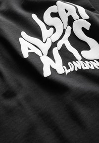 Čierna látka s vystúpeným bielym textom "ASAI ATS N LONDON" tučným, skresleným písmom.