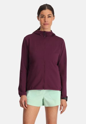 Giacca zip-up bordeaux con cappuccio, caratterizzata da una texture sottile e due tasche frontali, abbinata a pantaloni corti verde menta.