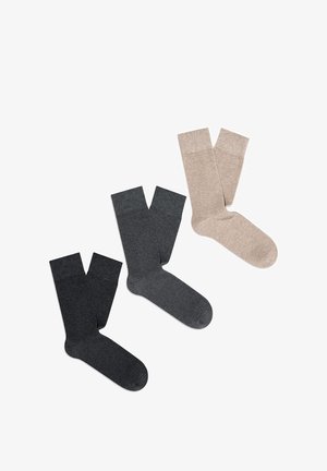 Trzy pary skarpetek wyeksponowane: jedna w ciemnoszarym, jedna w średnioszarym, a jedna w beżowym. Wykonane z miękkiej, teksturowanej tkaniny z gładkimi brzegami.