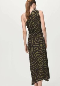 Luźna sukienka midi w kolorze khaki w czarne paski w wzór zebry, o asymetrycznym kroju, wykonana z lekkiego materiału, bez rękawów z delikatnym marszczeniem.