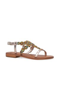 Fladsandal med en metallisk guldoverflade, farverig perlesmykke foran og en brun lædersål. Justerbar ankelrem.