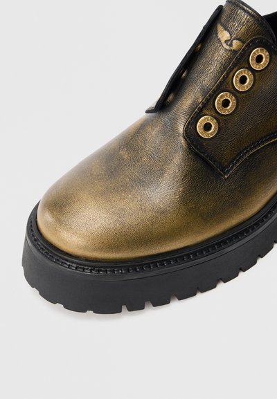 Stiefel aus metallisch goldenem Leder mit abgerundeter Spitze, schwarzer Gummisohle und goldenen Ösen auf der Zunge. Strukturierte Oberfläche, keine Schnürsenkel.