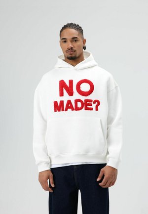Witte sweatshirt met capuchon, met rode geborduurde tekst "NO MADE?" op de voorkant. Voorzien van een voorzak en geribbelde manchetten.