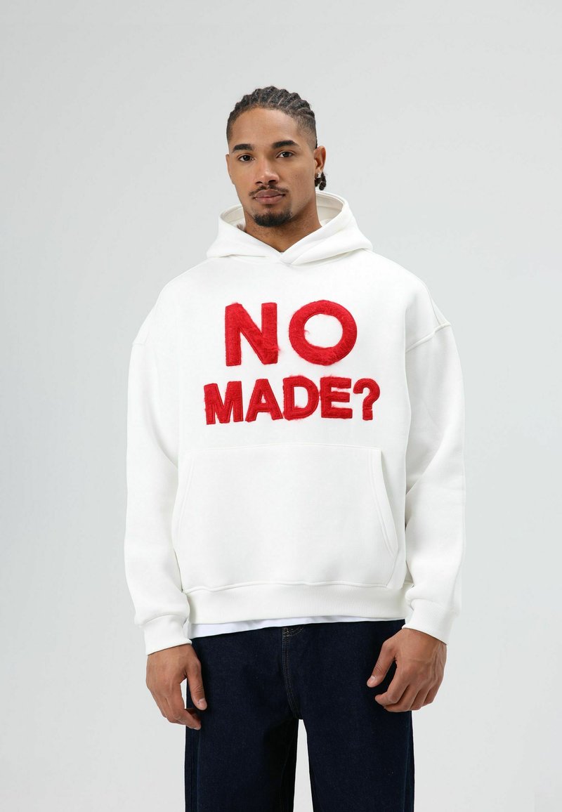 Witte sweatshirt met capuchon, met rode geborduurde tekst "NO MADE?" op de voorkant. Voorzien van een voorzak en geribbelde manchetten.