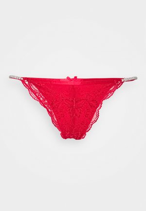 Red lace thong with floral pattern, elastic waistband, and satin ribbon accent. Features a delicate design and sophisticated detailing.
