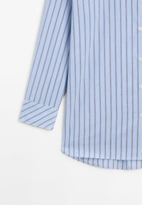 Light blue button-up shirt with vertical stripes in darker blue and white. Features long sleeves with cuff details and rounded hem.