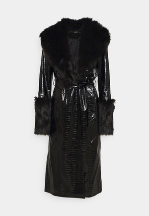 Long manteau noir en simili cuir avec une texture crocodile, col oversized en fausse fourrure, poignets en fausse fourrure et une ceinture à la taille.
