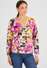 Cardigan en mailles multicolores à motif floral rose, jaune et noir, avec un col en V et une fermeture à boutons, fabriqué en tissu tricot doux.