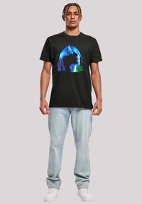 Black cotton t-shirt featuring a blue and green graphic design of a profile, with short sleeves and a regular fit.
