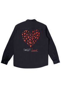 Črna majica z dolgimi rokavi featuring velik rdeč srčni vzorec, narejen iz manjših srčkov, in besedilo "SWEET heart" v belih in rdečih vezeninah.